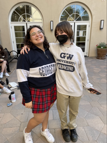 Emily Vargas 22 and Olivia Sandford 22 pose wearing their college sweatshirts in Cornelias Courtyard. 
