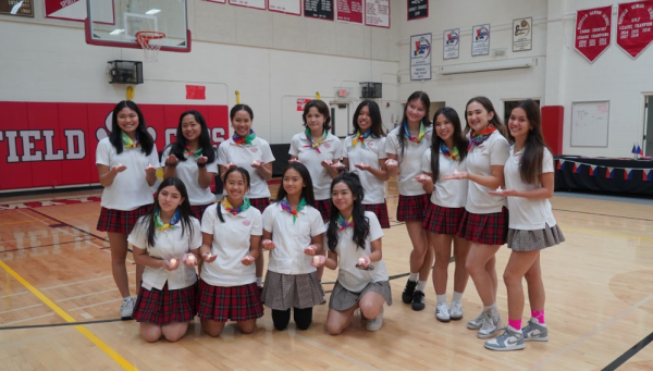 Adorning colorful handkerchiefs and holding candles, Mayfield students pose after learning the traditional Philippine folk dance Pandanggo sa ilaw under the direction of a dance instructor.  Photo credits: Mayfield Crier